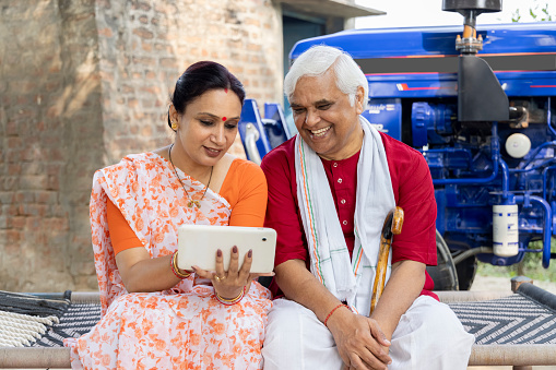 Indian rural daughter and grandfather using tablet at village