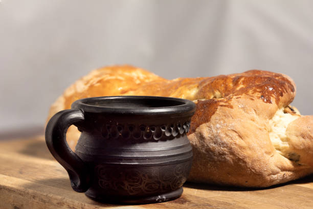 poppy seed roll with black clay cup on aged wood close-up