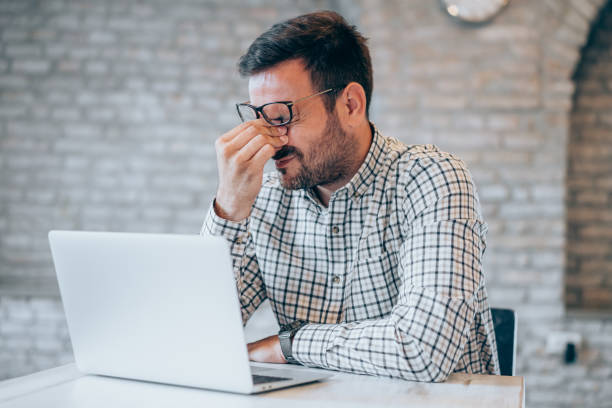 istock Stressed businessman having headache while working on laptop in the office. 1444490743