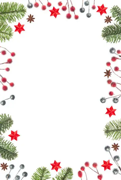 Photo of Christmas frame of tree branches, red berries and stars isolated on white background