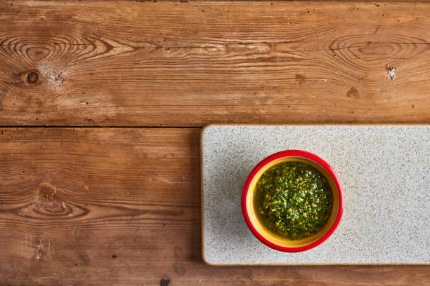Fresh basil pesto sauce on cutting board stock photo