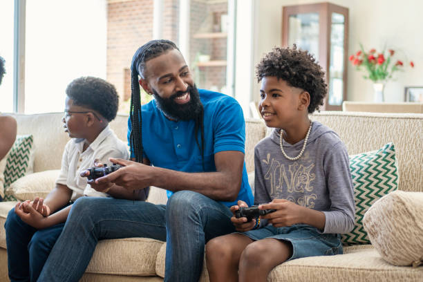 istock Father playing video game with his boys  on sofa 1444496411