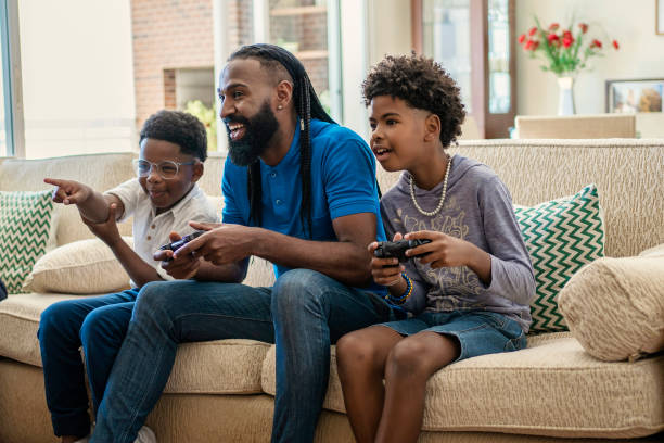 istock Father playing video game with his boys  on sofa 1444496414