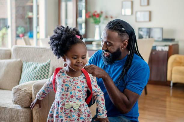 istock Father helping daughter to put lunch box at home 1444496489