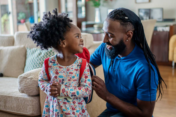 istock Father helping daughter to put lunch box at home 1444496490