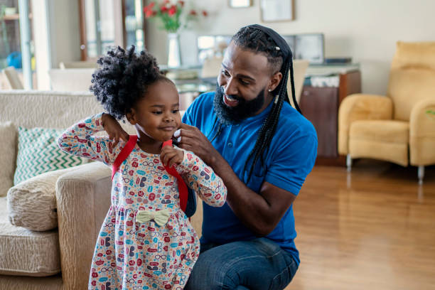 istock Father helping daughter to put lunch box at home 1444496493