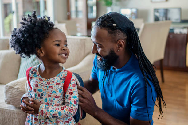 istock Father helping daughter to put lunch box at home 1444496517