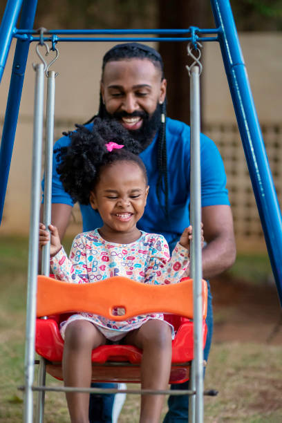 istock Father and little daughter on a swing on playground 1444496746