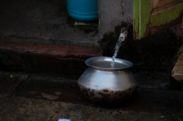 istock Water pouring in a aluminium handi in a street side water source 1444498171