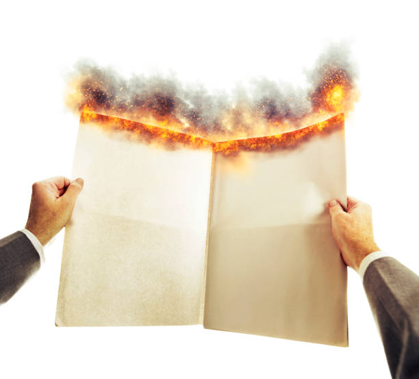 istock Hot news: Businessman's hands hold a blank burning newspaper with space for copy 1444499918