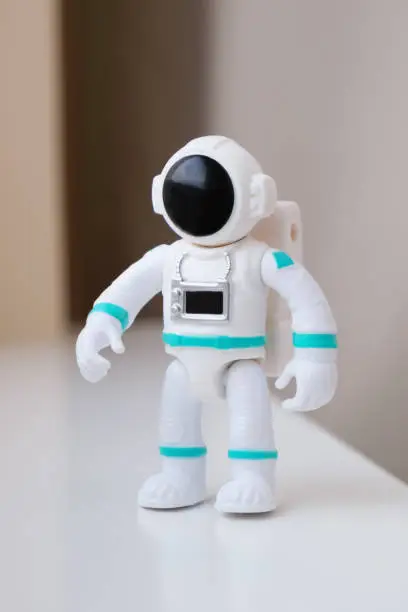 Plastic figurine of an astronaut in a spacesuit. Children's toy astronaut. Fascination with space, the study of planets.