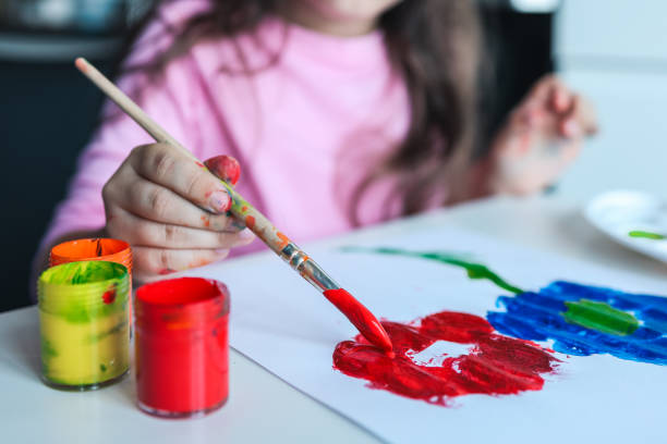 istock Child draws flowers with paints 1444507588