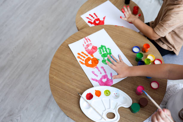 istock Children's drawing workshop, happy children make handprints with paint 1444507609