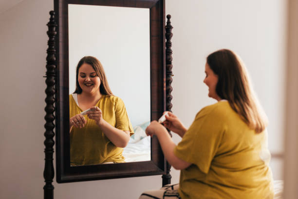 istock Woman Applying Creme While Looking At Herself In The Mirror 1444508145