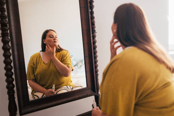 istock Woman Applying Creme While Looking At Herself In The Mirror 1444508146