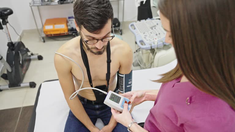 Doctor puts a holter on a man's chest