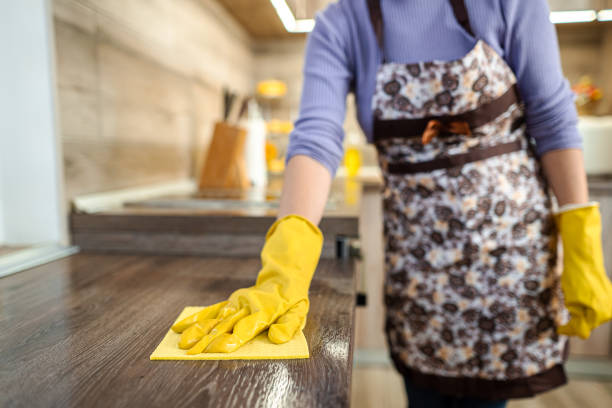 frau mit gelben reinigungsmitteln reinigt eine arbeitsplatte. - cleaning domestic kitchen counter top housework stock-fotos und bilder
