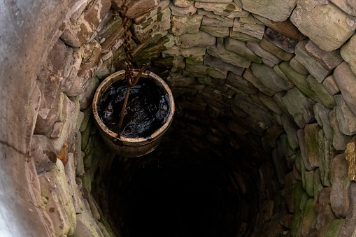 Sucevita, Romania, 2021-12-29. A bucket of water is brought up from the well in the monastery of Sucevita in the Bucovina region.