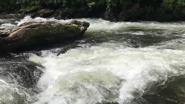 The Chattooga River and waterfalls flowing in the rain, slow motion