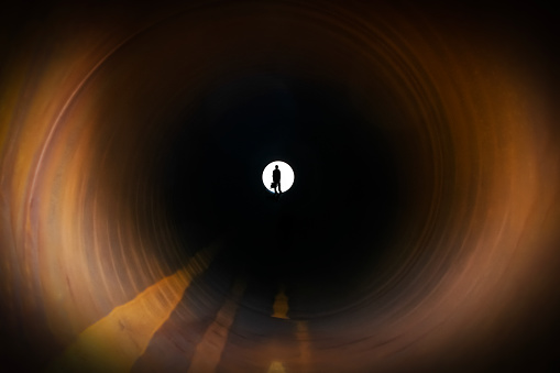 Silhouette of businessman at the end of the tunnel.