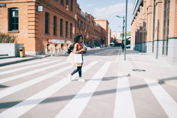 istock Woman speaking on smartphone crossing road 1444517034