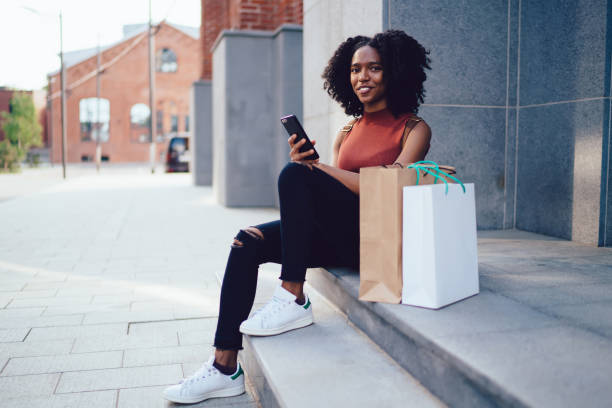 istock Smiling black woman texting on smartphone 1444517238