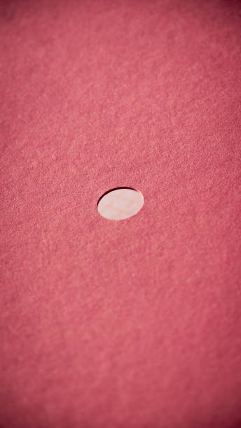 istock Round hole in pink cardboard folder 1444519467