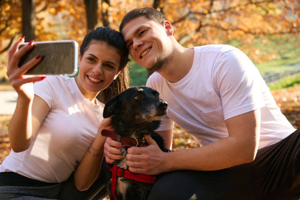 istock Young people take selfie in autumn park with their dog 1444525046