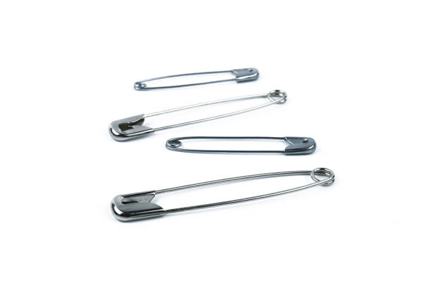 istock Safety pins standing one after another isolated on white background 1444529304