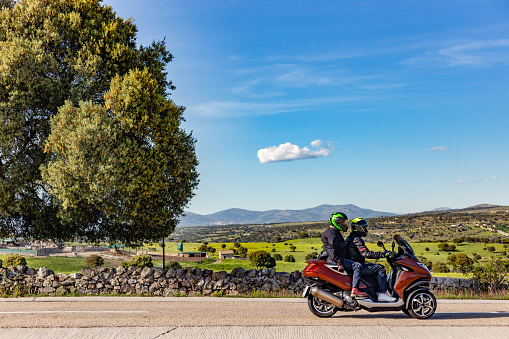 Madrid Spain. May 7, 2022. Biker couple driving along a rural road on a bright spring afternoon