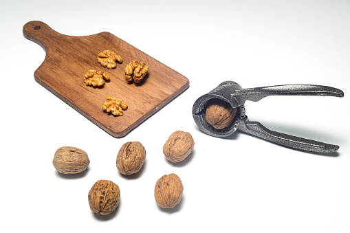 Walnuts with nutcracker isolated on white background
