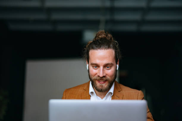 istock Smiling Businessman Talking On A Video Call Using A Laptop Computer In The Office 1444535529