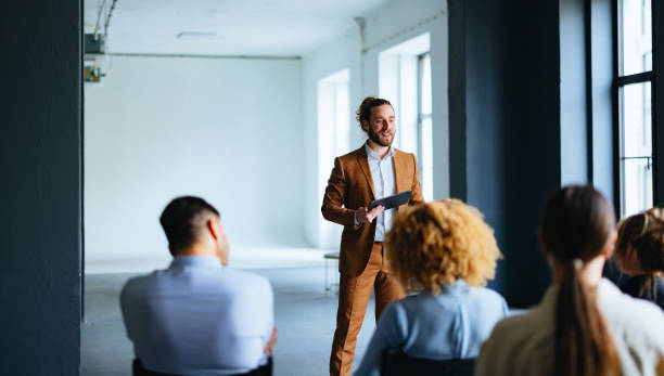 istock Happy Business Man Holding A Digital Tablet And Talking To Audience During A Presentation 1444535604