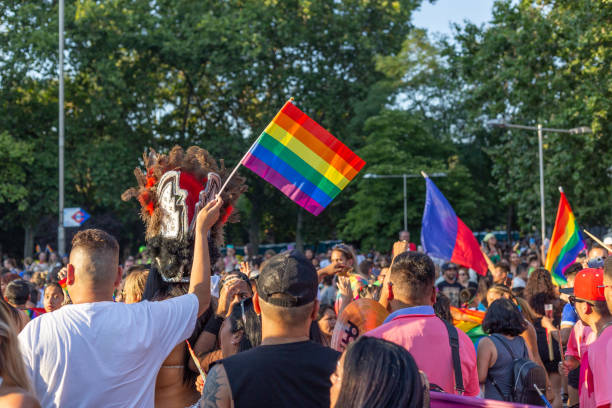 rear view of attendees and participants in the gay pride parade in madrid waving rainbow flags - foton med överkroppsbild bildbanksfoton och bilder