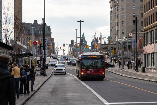 Ottawa, Canada - November 10, 2022: Bus on Rideau Street in the city center. People are waiting at the bus stop for a trip by public transport