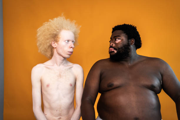 amigos masculinos mirándose sobre un fondo naranja - shirtless men bizarre male fotografías e imágenes de stock