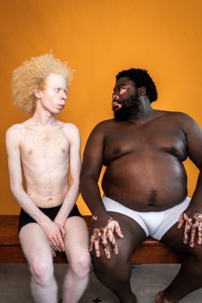 male friends looking at each other on an orange background - shirtless men bizarre male imagens e fotografias de stock