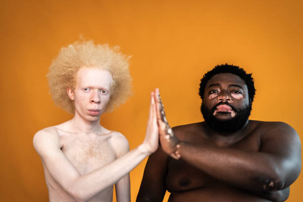 retrato de amigos varones chocando los cinco sobre un fondo naranja - shirtless men bizarre male fotografías e imágenes de stock