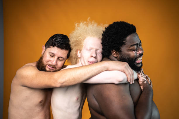 amigos varones abrazados sobre un fondo naranja - shirtless men bizarre male fotografías e imágenes de stock