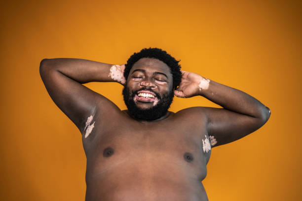 istock Mid adult man with hands behind head on an orange background 1444537240