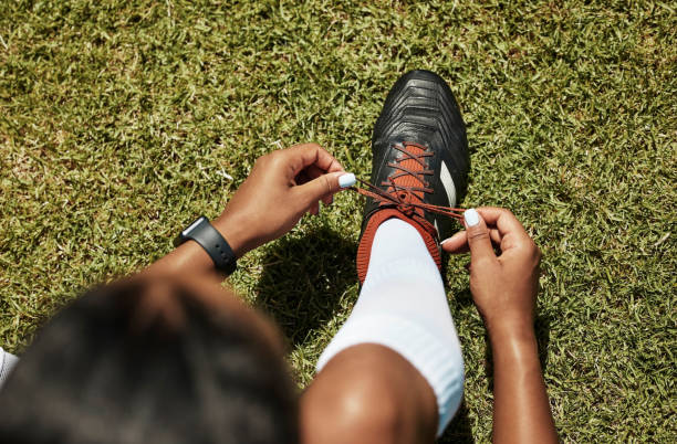 Shoes tie, sports and soccer black woman athlete on green grass ready for exercise and training. Fitness, workout and game of a healthy person player before football cardio in nature and summer Shoes tie, sports and soccer black woman athlete on green grass ready for exercise and training. Fitness, workout and game of a healthy person player before football cardio in nature and summer bound woman stock pictures, royalty-free photos & images