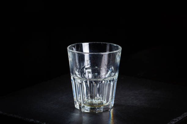 istock Faceted empty glass stands on a black slate plate. 1444540587