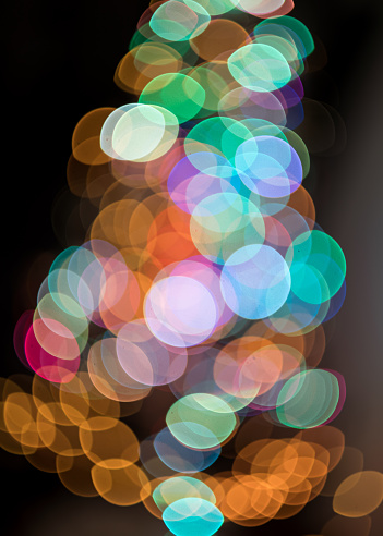 Defocused Image Of Illuminated Christmas Tree Against Black Background