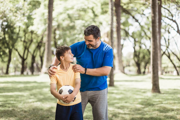 istock Father and son playing soccer in the park 1444547170