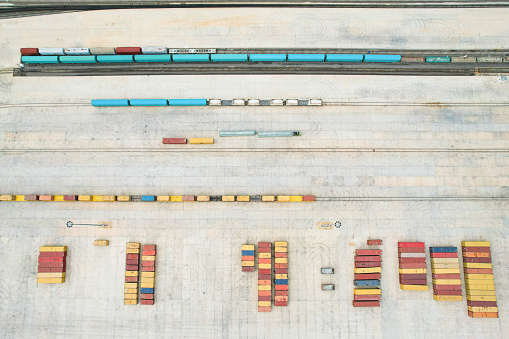 default
Drone view of transport containers in logistics center lined up and train tracks on its side