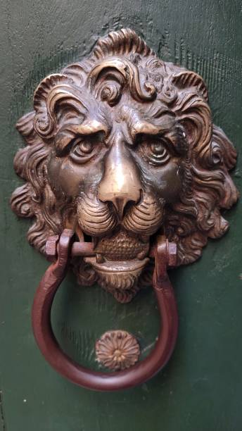 istock Antique copper door handle on a green door, close-up 1444548933