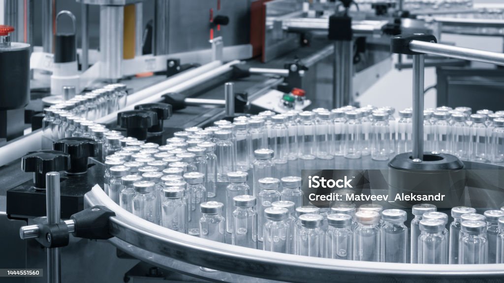 Pharmaceutical industry. Production line machine conveyor with glass bottles ampoules at factory. Pharmaceutical industry concept background. Pharmaceutical Industry Stock Photo Pharmaceutical industry. Production line machine conveyor with glass bottles ampoules at factory. Pharmaceutical industry concept background. Pharmaceutical Industry Stock Photo
