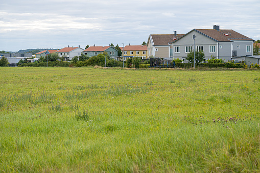 Row of residential houses by a green field.