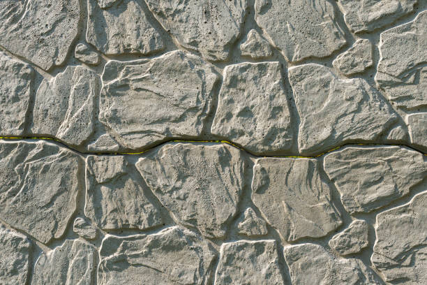 istock Concrete decorative fence from panels. A panel fence with a natural stone-like texture. Solid background 1444556676