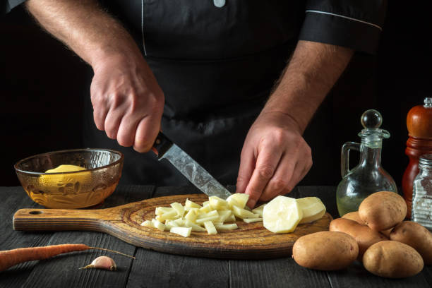 istock Before preparing the national dish, the chef cuts raw potatoes into small pieces with a knife. Close-up of a cook hands while working in a restaurant kitchen 1444560384
